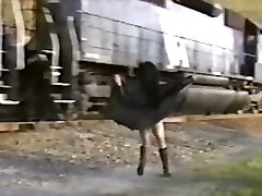 Asian girl in trench coat flashes train