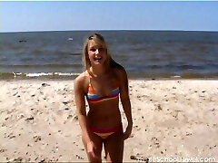 Hula hooping hottie on the beach in a colorific bikini