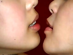 2 Japanese girls are doing some weird kissing with a mouth speculum