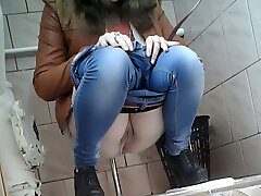 Slender doll in very tight blue jeans filmed in the toilet room