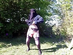 Muslim Burqa flashing outdoors in stocking and suspenders