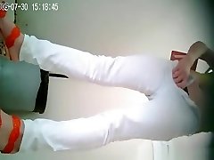Asian woman in white pants pissing