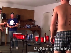 Buddies play your ever beer pong in a a garage