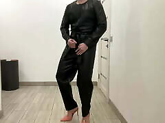Tranny in a leather jumpsuit romper and high heels BDSM